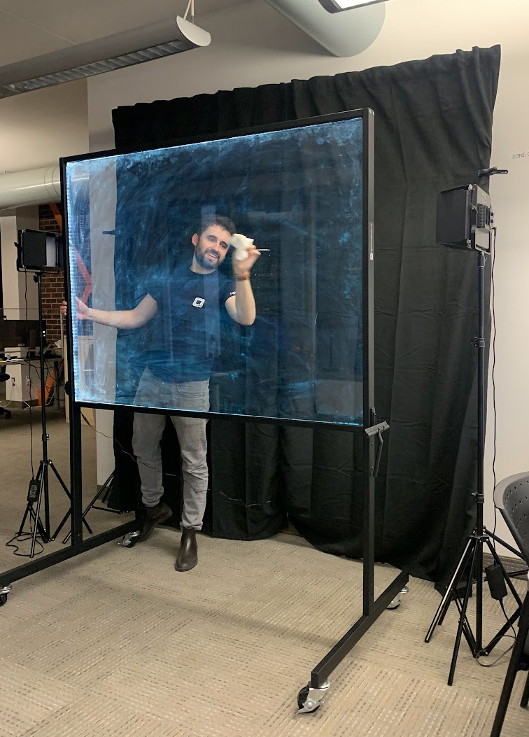 Our team cleaning a freshly assembled Lightboard in front of the studio backdrop and lights