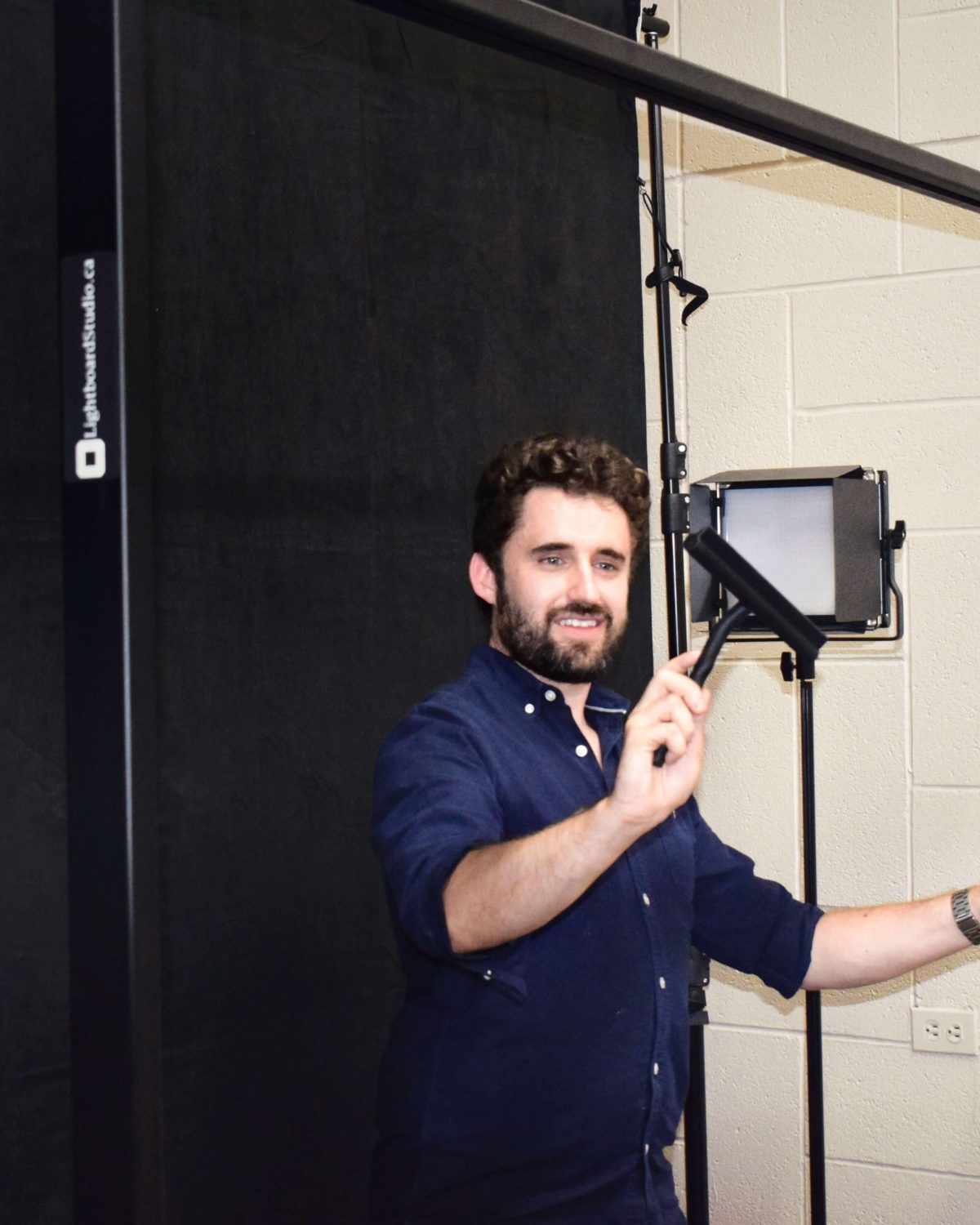 Black squeegee being-used on lightboard