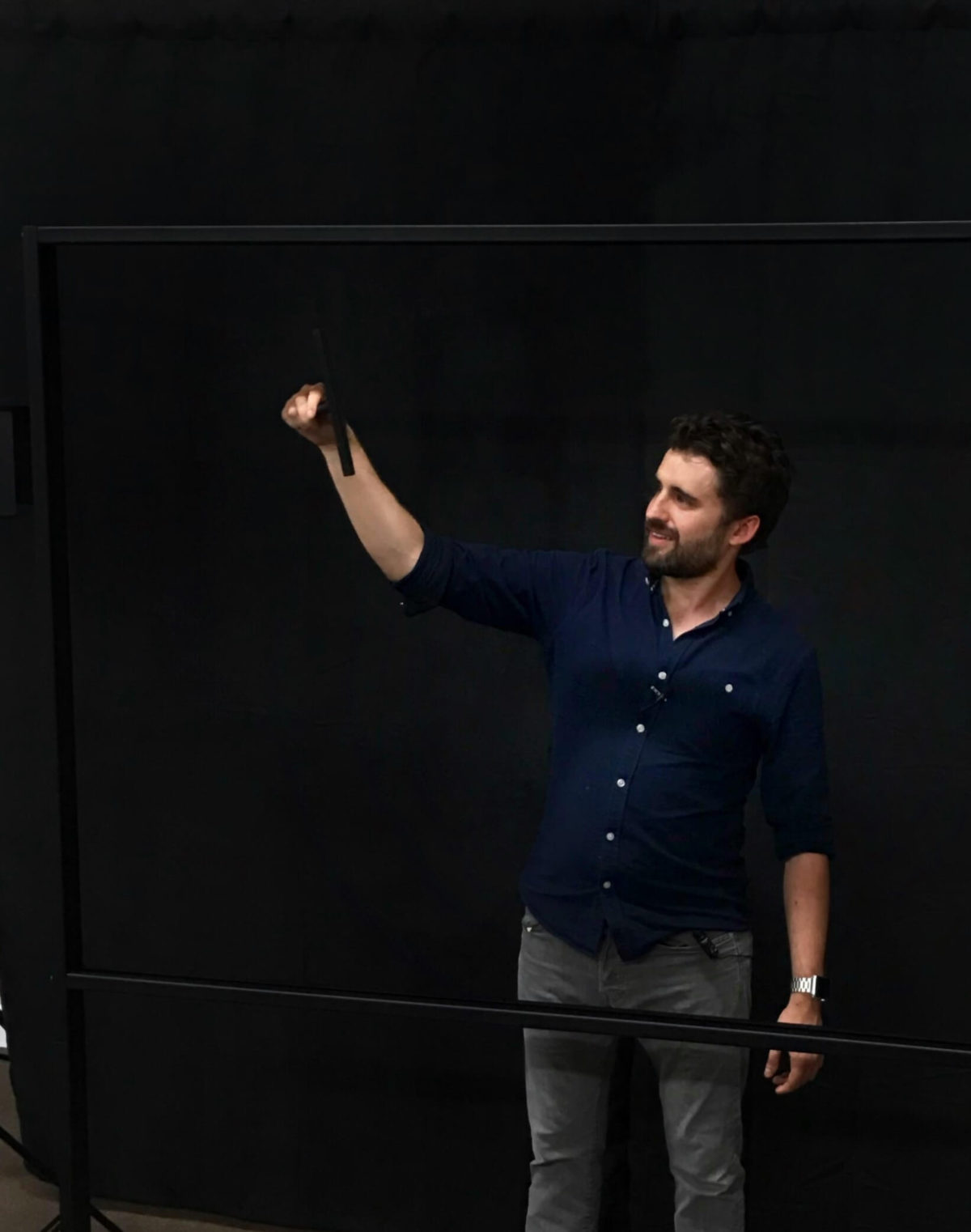 Person using the black squeegee on lightboard